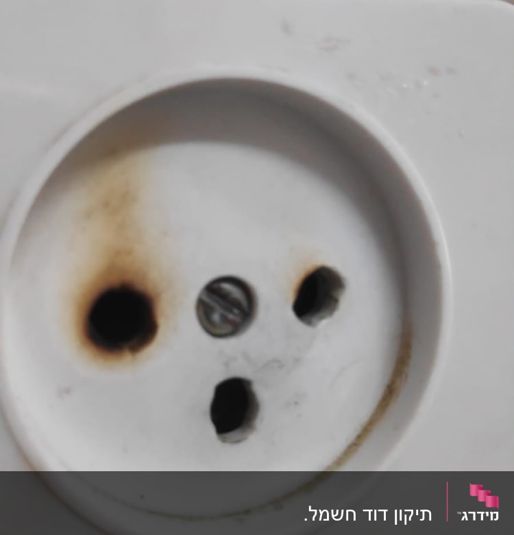 שקע חשמלי עם סימני שריפה סביב החורים